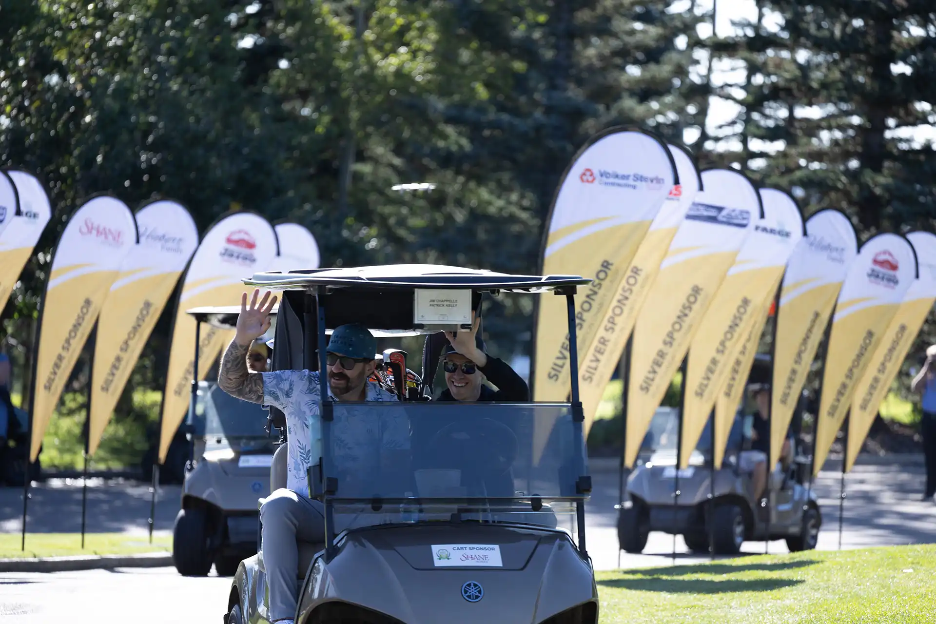 Blue Prostate Cancer Centre tent and banner with volunteers running a 50/50 raffle on the golf course at Priddis Greens during the AGAT Priddis Greens Charity Classic.